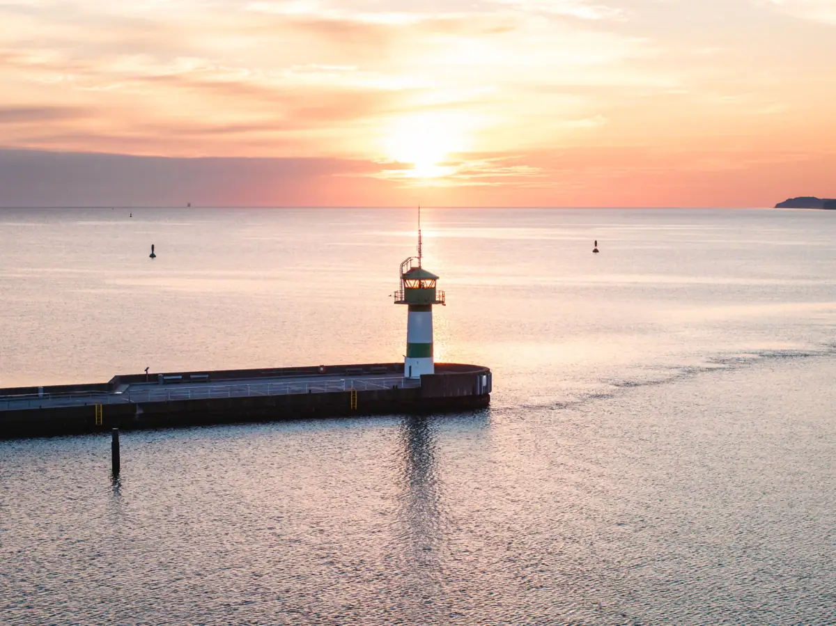 Ein Pier mit einem Leuchtturm im Wasser.