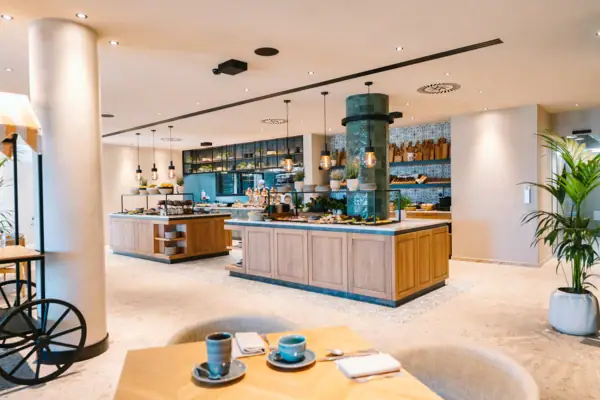 Ein Restaurant mit Buffet. Es sind verschiedene Stationen zu sehen, die unterschiedliches Essen präsentieren.