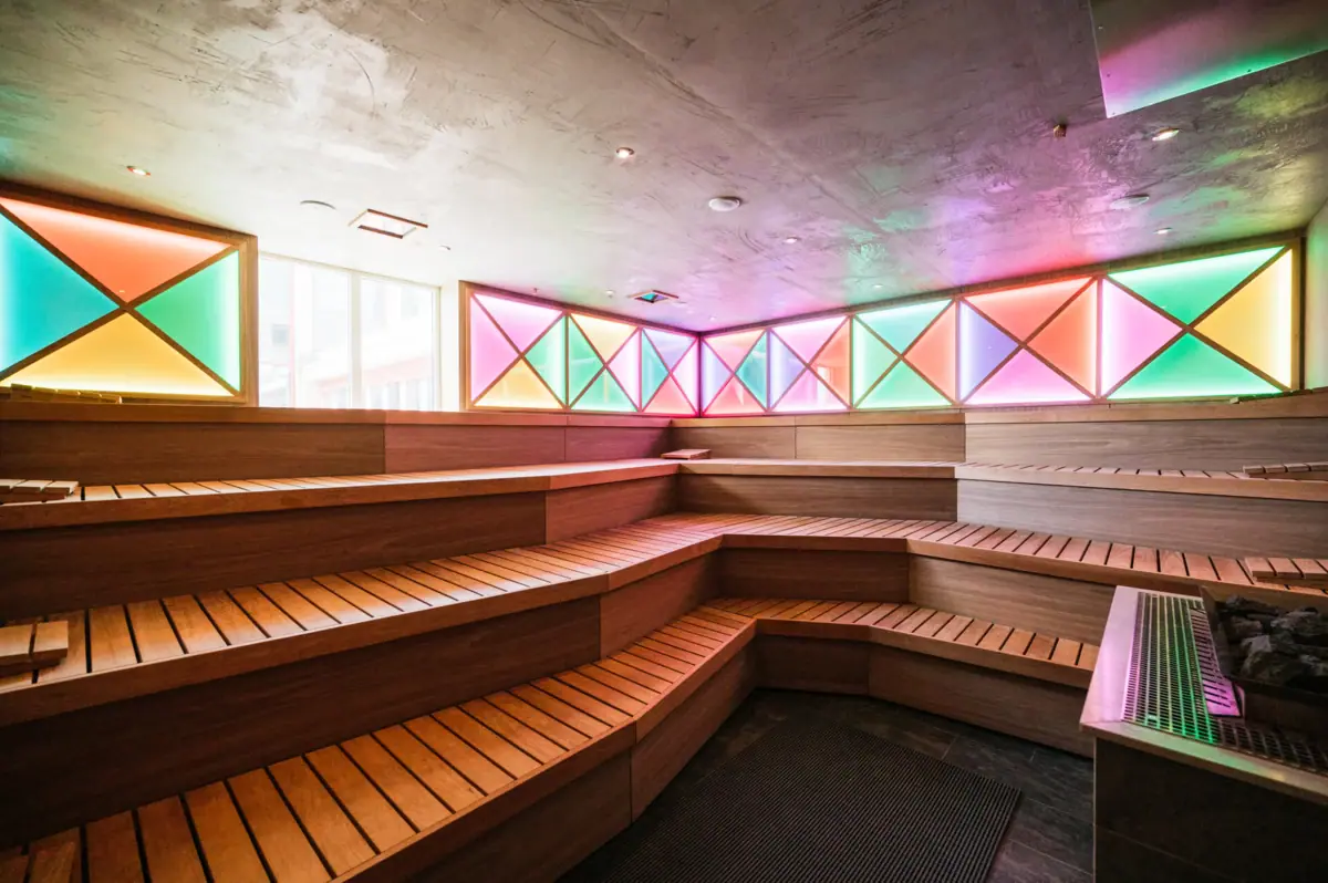 Saunaraum Holzbänken und bunten Lichtern