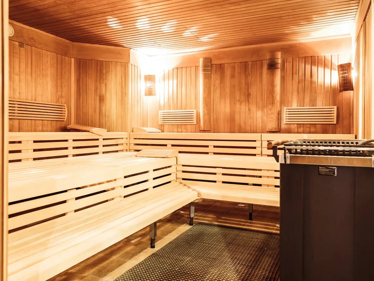 Sauna mit Holzbänken und Grill im Innenbereich