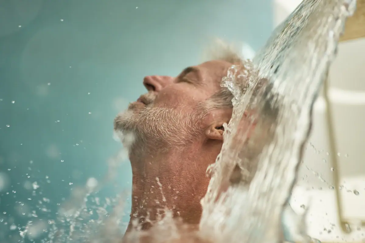 Ein Mann unter einem Wasserfall.