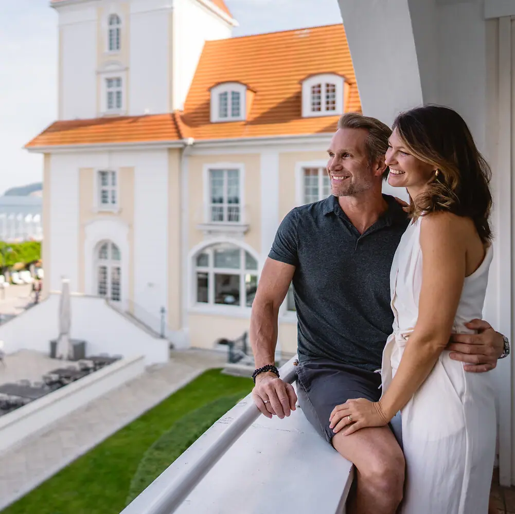 Ein Mann und eine Frau sitzen auf einem Balkon.