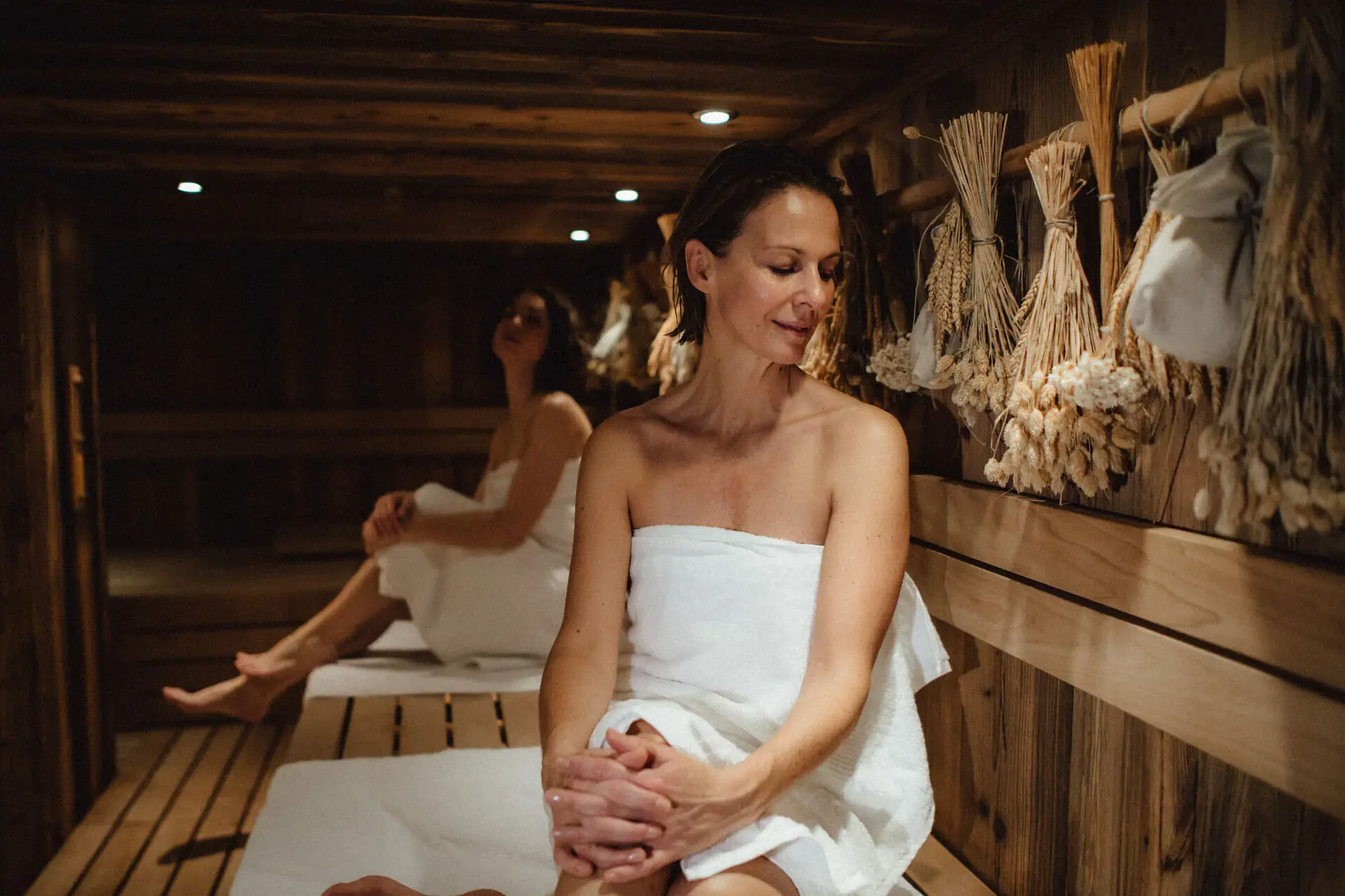 Frau in einem Sauna sitzend, trägt ein Hochzeitskleid.