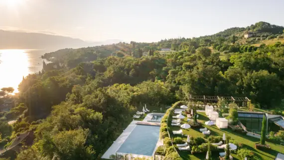 A pool surrounded by trees in the open air.