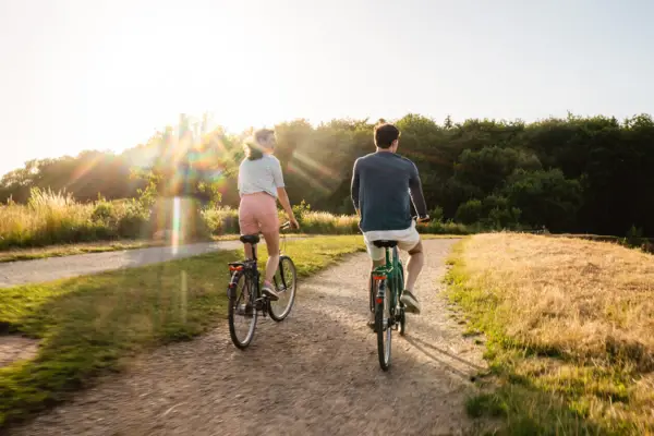 Ein Mann und eine Frau fahren auf einem Weg Fahrrad.