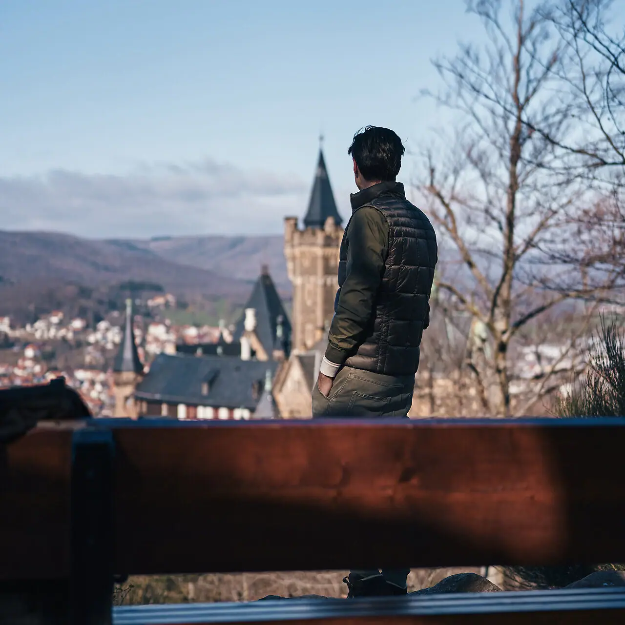 Ein Mann steht vor einer Bank und schaut auf ein Schloss.