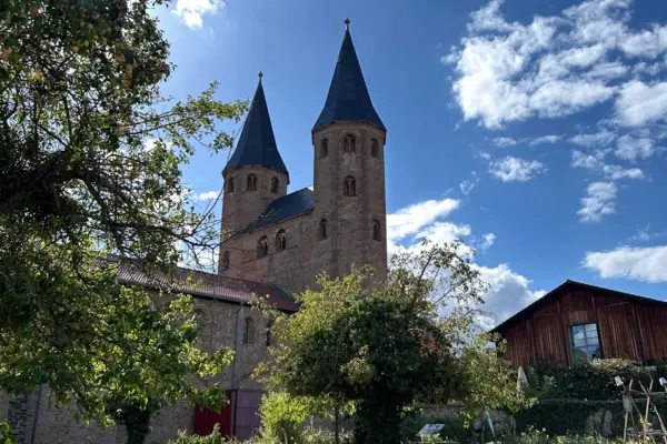 Ein Gebäude mit Türmen und Bäumen im Vordergrund.