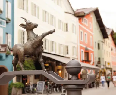 Statue einer Ziege auf einem Metallpfosten in der Altstadt von Kitzbühel.
