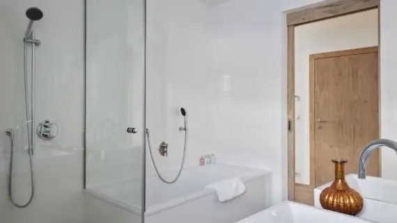 Ein weißes Badezimmer mit einer gläsernen Duschkabine und einer Badewanne.