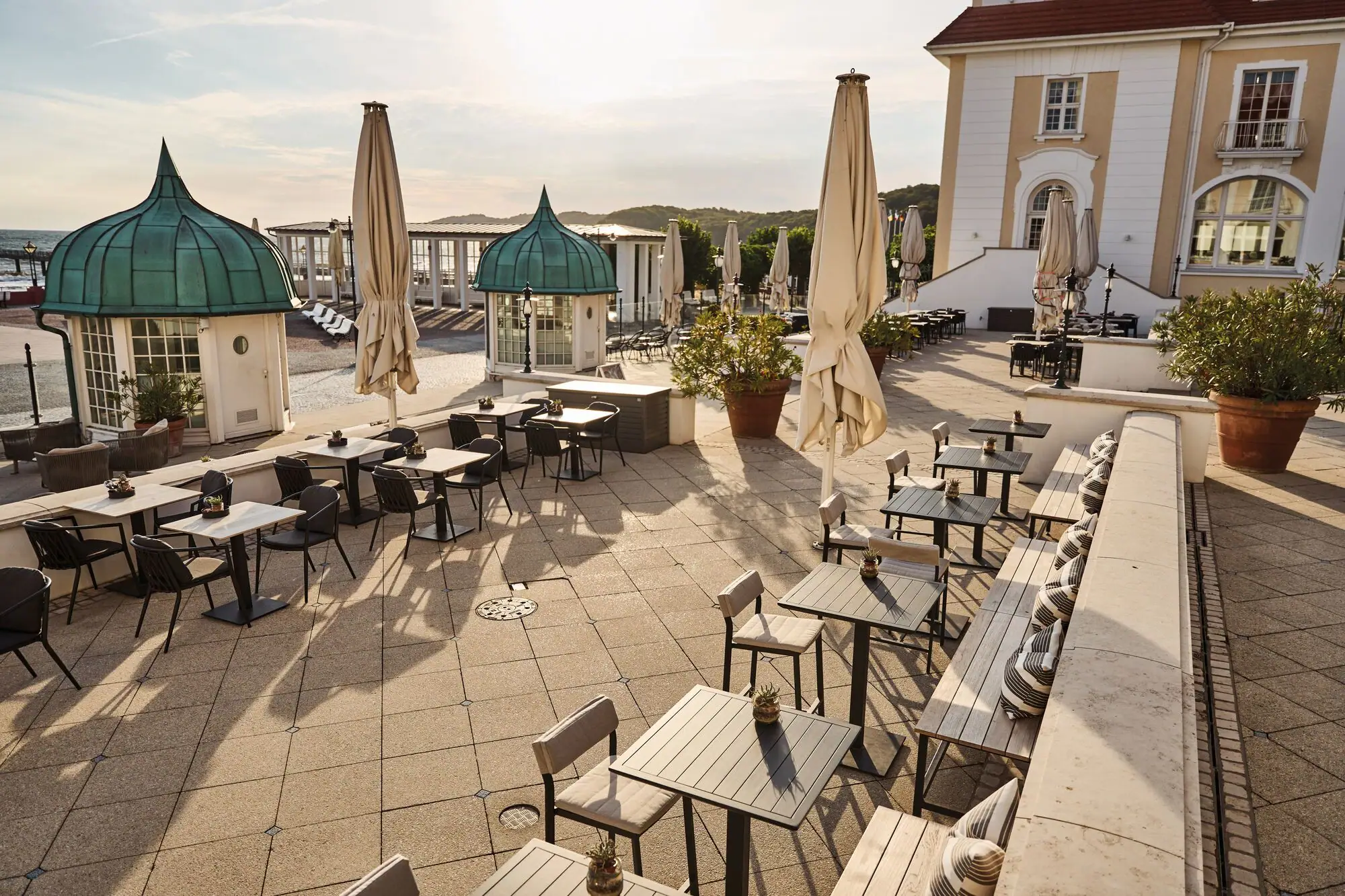 Terrasse mit Tischen und Sonnenschirmen