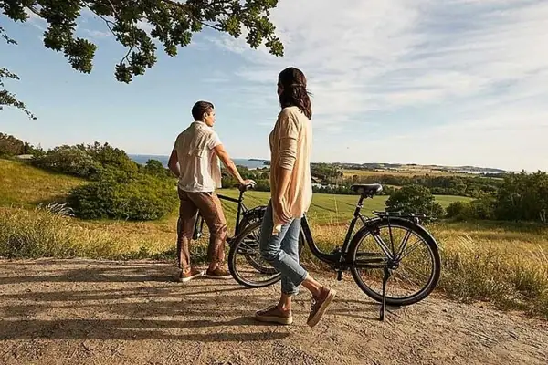 Ein Mann und eine Frau stehen neben Fahrrädern im Freien.