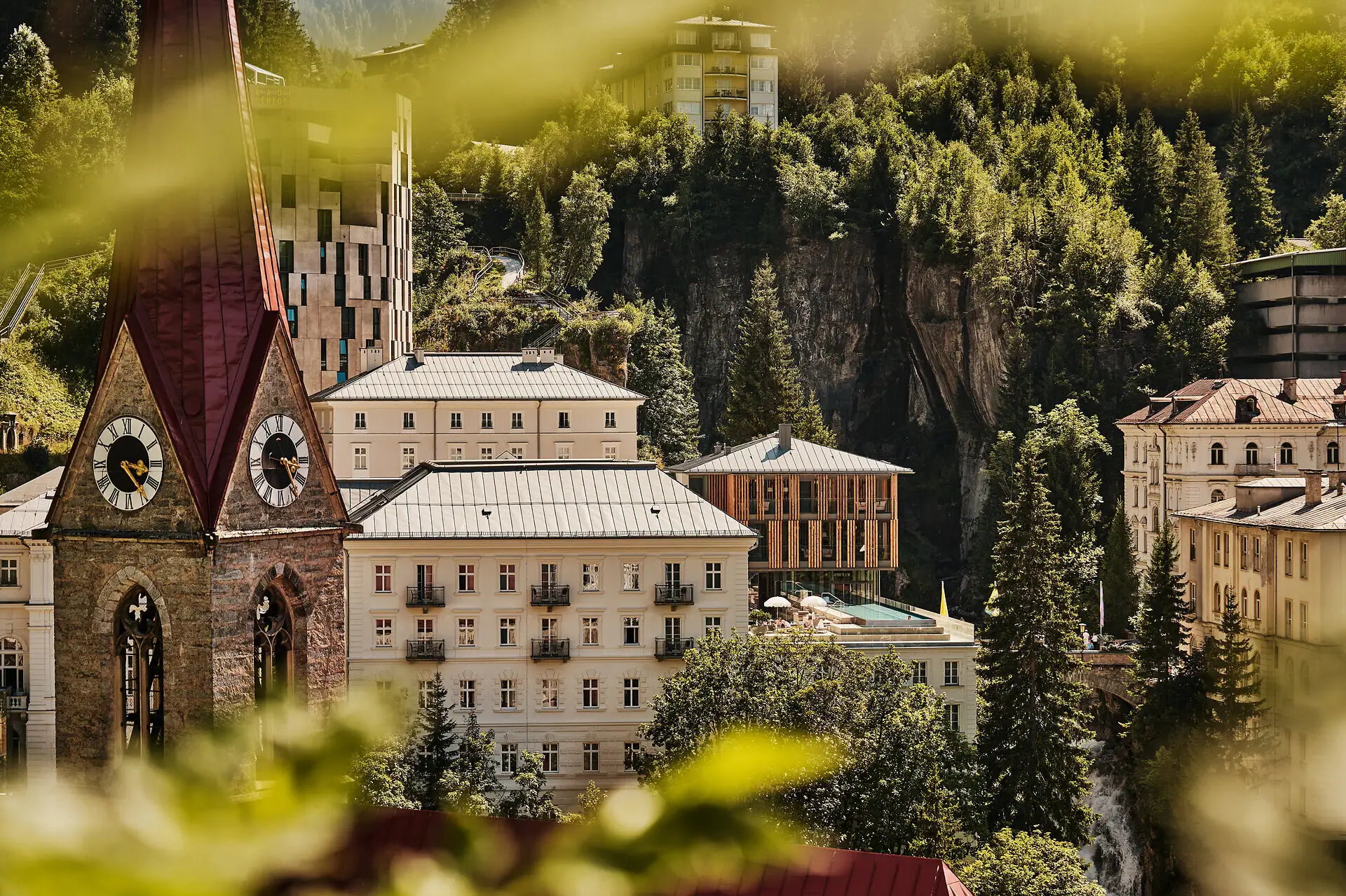 Eine Gruppe von Gebäuden mit Bäumen und Bergen im Hintergrund.