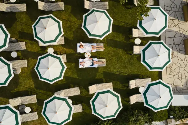 Ein Paar liegt auf einer Wiese mit Sonnenschirmen.