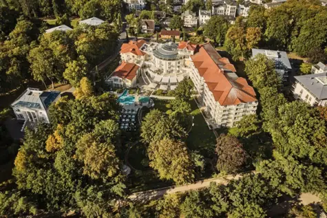 Luftansicht vom A-ROSA Heringsdorf umgeben von grünen Bäumen. 