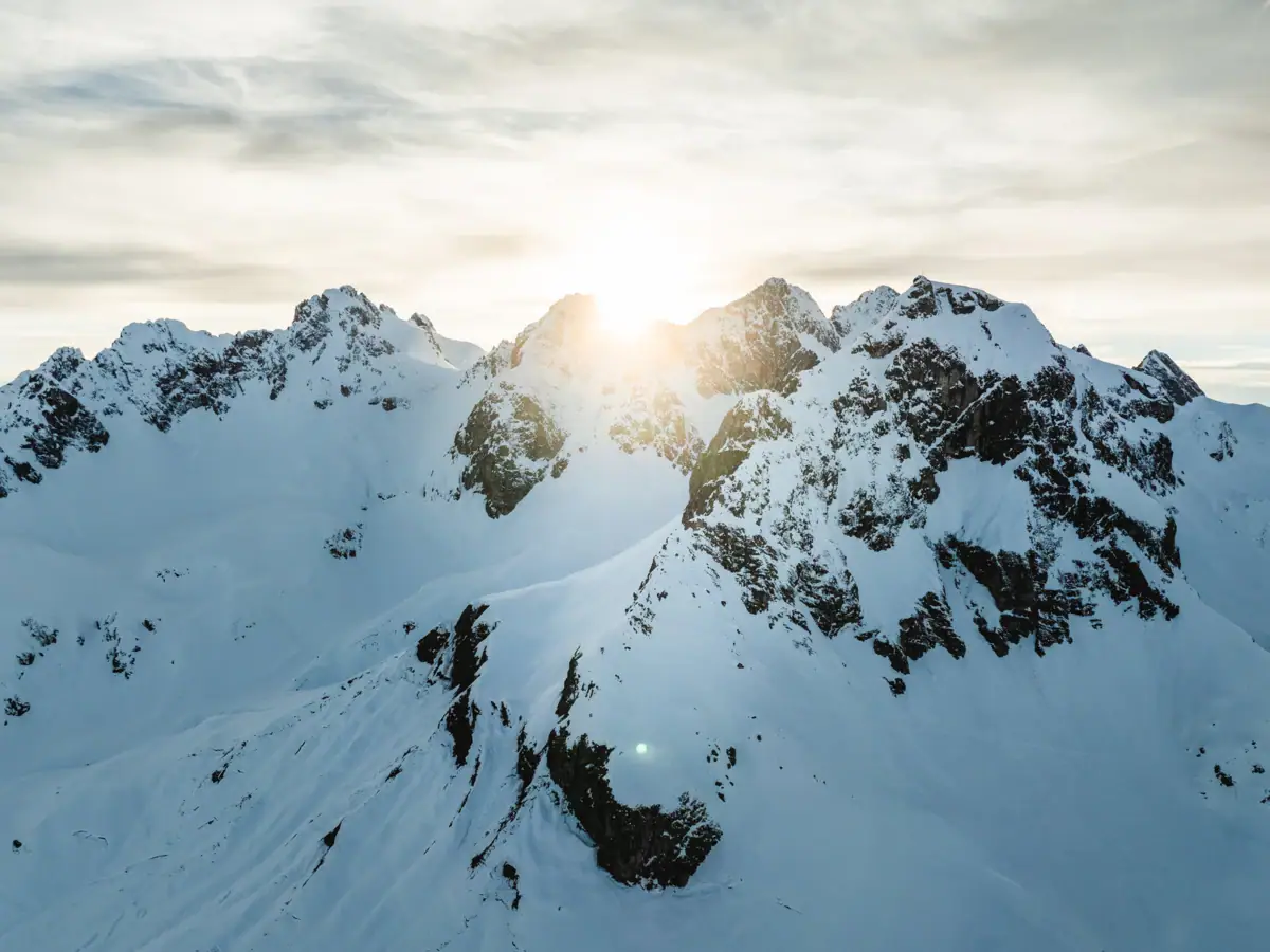 Verschneite Berggipfel mit Sonnenschein.