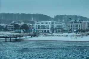 Schneebedeckter Strand mit Gebäuden im Winter.
