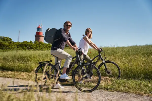 Ein Mann und eine Frau fahren mit Fahrrädern auf einem Weg.