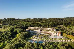 Ein Gebäude mit einem Pool, umgeben von Bäumen.