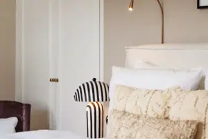 Ein Bett mit Kissen und einer Lampe.