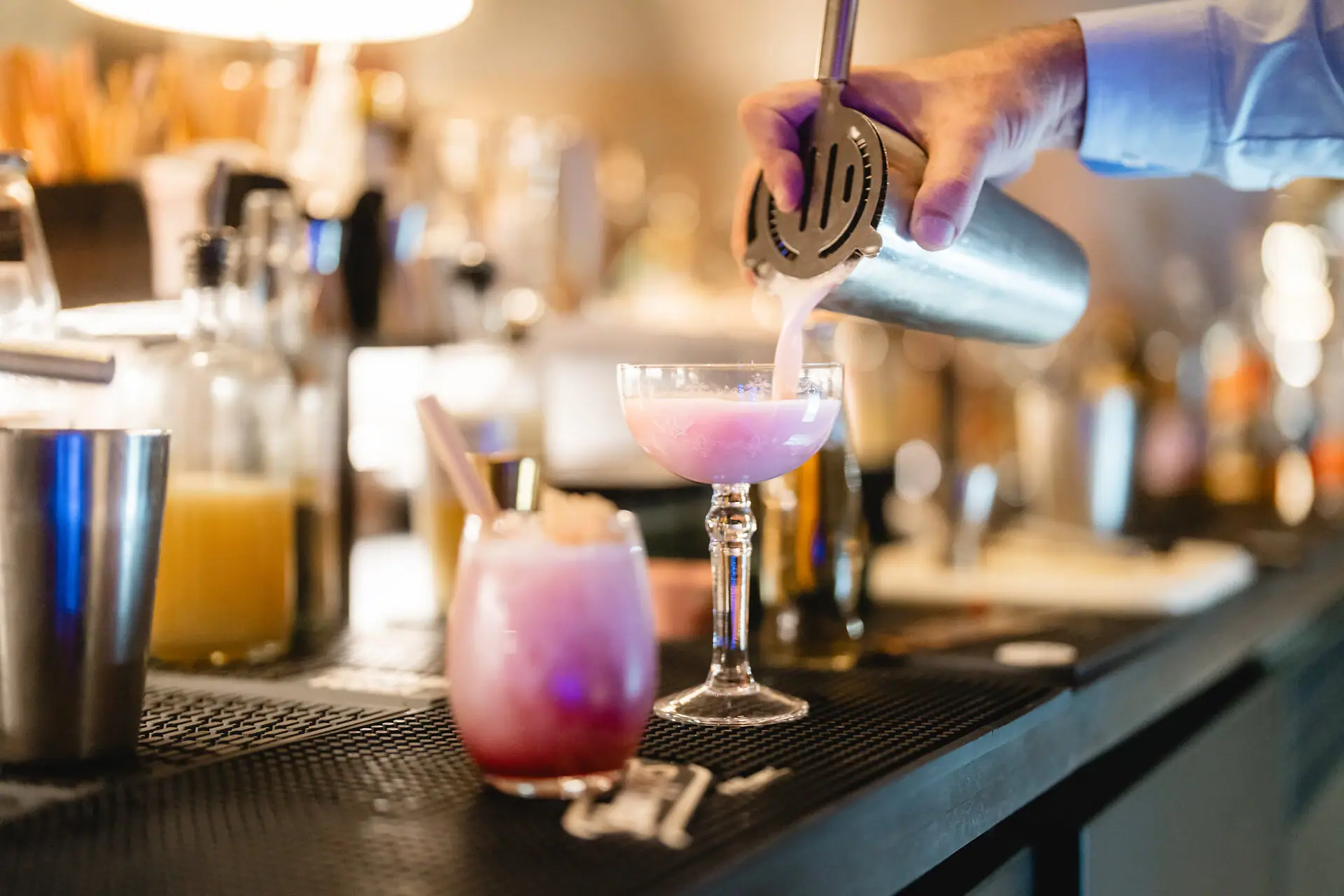 Eine Person gießt ein Getränk in ein Glas ein.