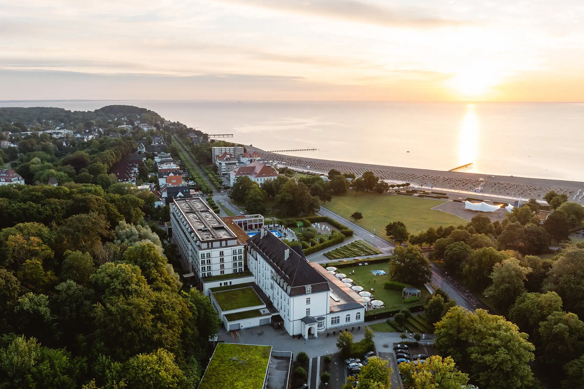 Luftaufnahme einer Stadt mit Bäumen und einem Gewässer