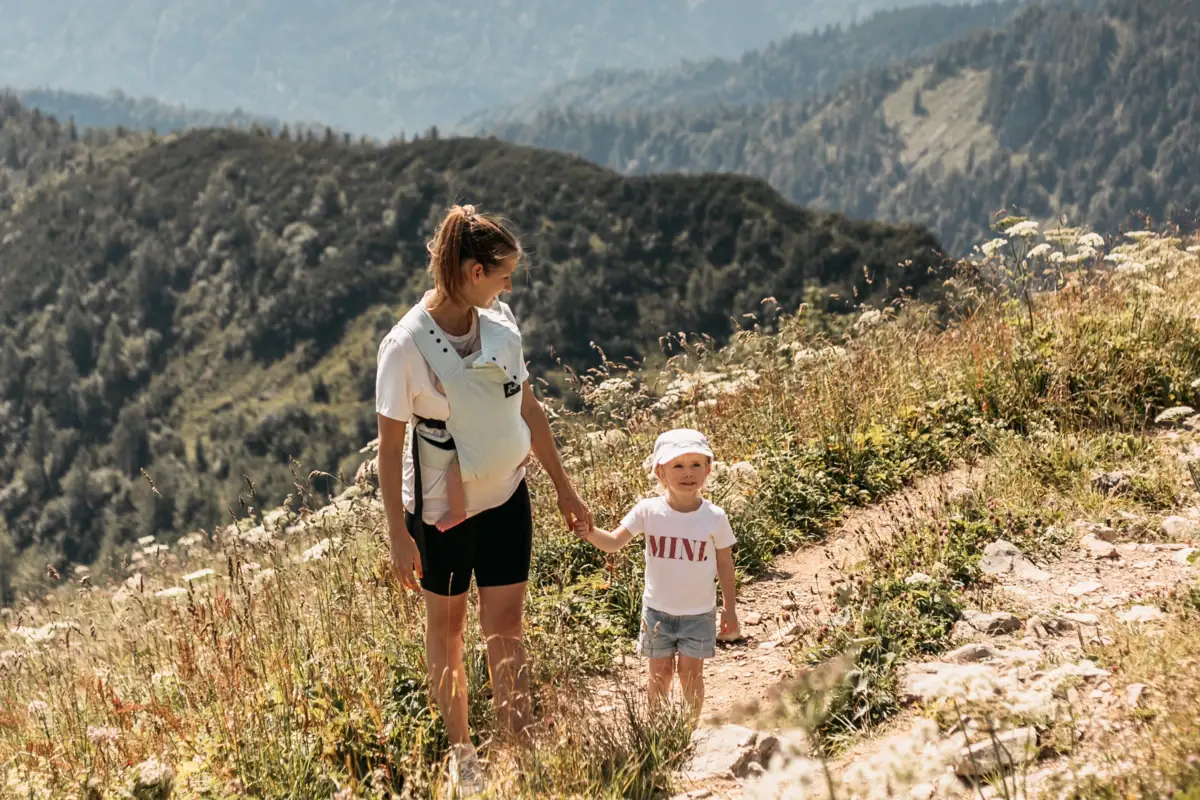 Eine Frau und ein Kind beim Wandern auf einem Berg.