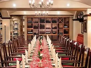 Ein Raum mit einem Tisch, der für eine Dinnerparty gedeckt ist, mit Kerzen und elegantem Interieur.