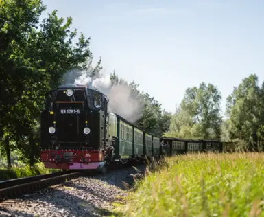 Zug auf Eisenbahnschienen unter freiem Himmel.