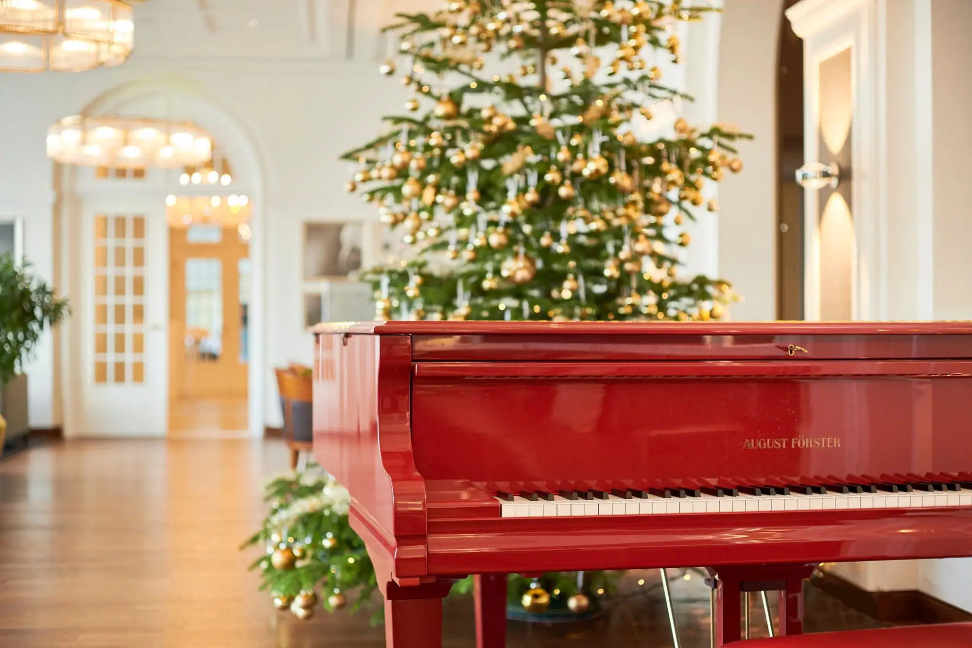 Rotes Klavier in einem Raum mit einem Weihnachtsbaum