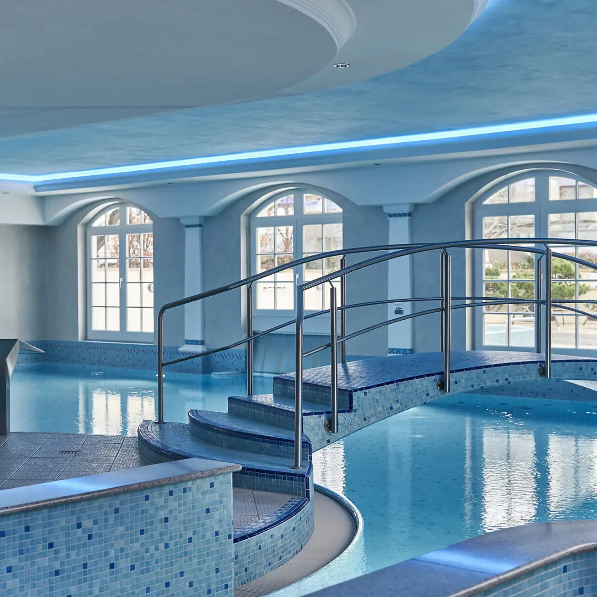 Ein Schwimmbecken mit geschwungenem Gehweg.