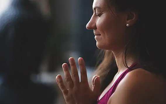 Eine Frau mit zusammengelegten Händen.