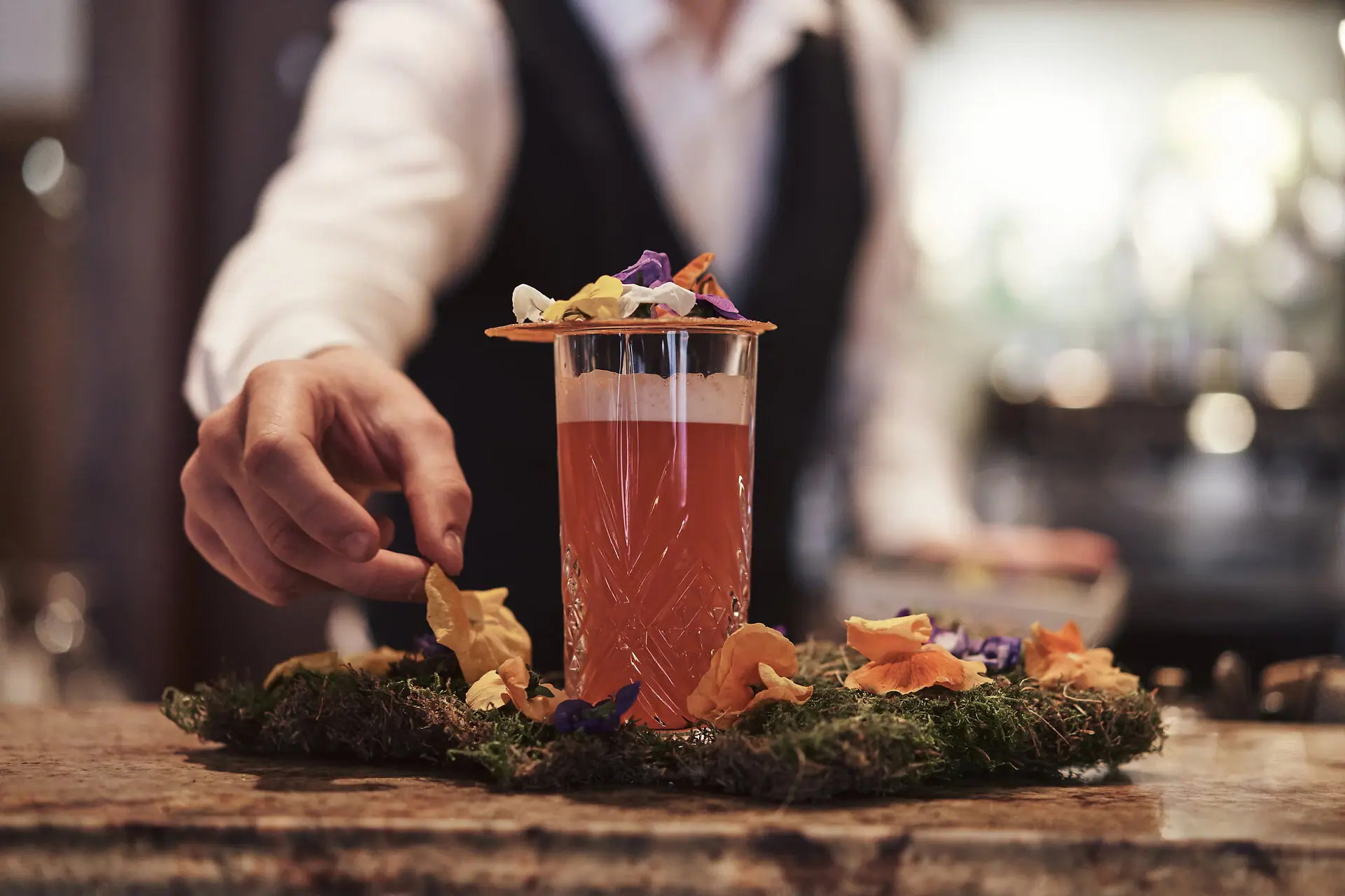 Person hält ein Getränk in einem Glas