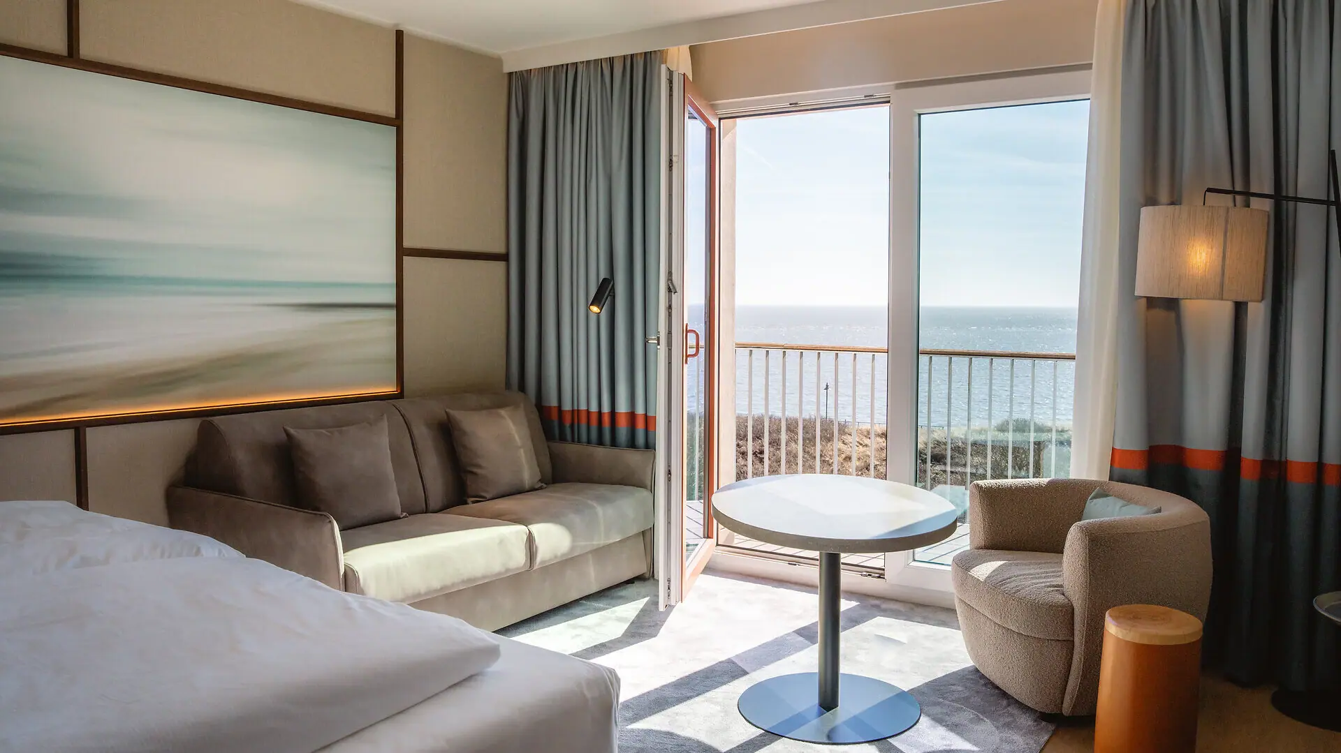 Hotelzimmer mit Bett, Couch und Tisch.