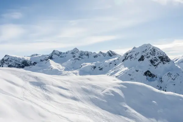 Verschneite Berggipfel unter blauem Himmel.