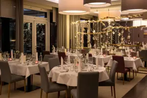 Ein Raum im A-ROSA Hotel mit Tischen und Stühlen, eingerichtet für Silvester auf Sylt.