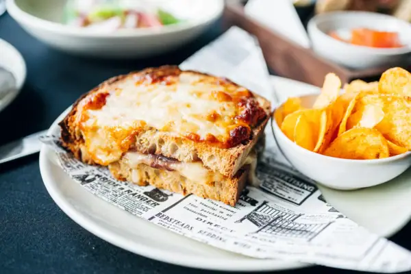 Sandwich mit Käse und Kartoffelchips auf einem Teller