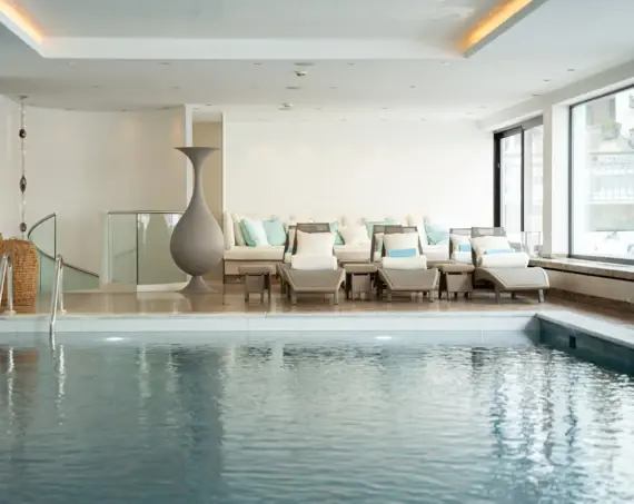 Ein Pool mit einem großen Vase und Stühlen.
