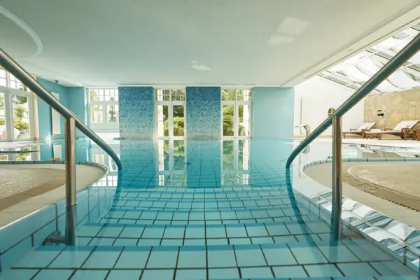 Ein großes Schwimmbecken in einem Innenbereich mit Treppen.