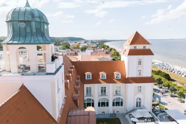 Ein Gebäude mit Glockenturm und Strand im Vordergrund.