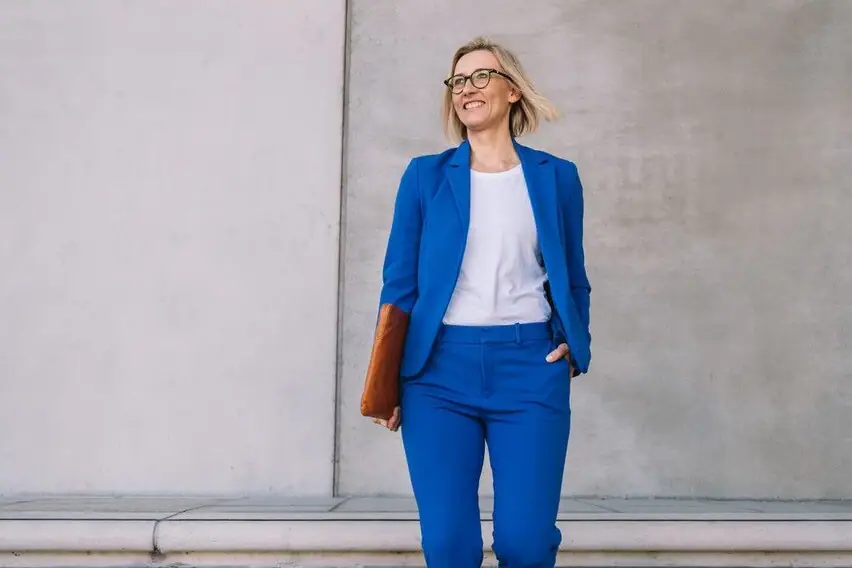 Frau im blauen Anzug geht eine Treppe hinauf.