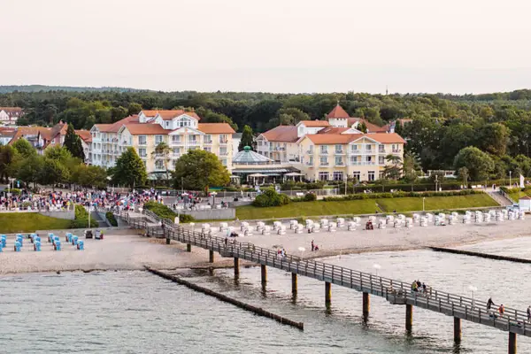 Luftaufnahme vom A-ROSA Kühlungsborn direkt am Strand und mit langem Steg, der auf das Wasser hinaus führt. 