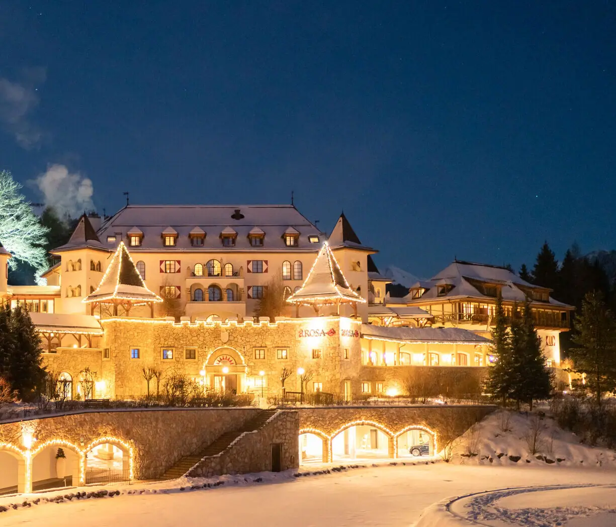 Ein beleuchtetes Gebäude im Freien bei winterlicher Umgebung.