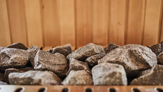 Layered stones on a sauna heater in a wooden sauna.