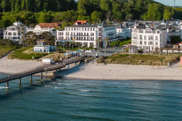 Strand mit einem Pier und Gebäuden im Hintergrund.