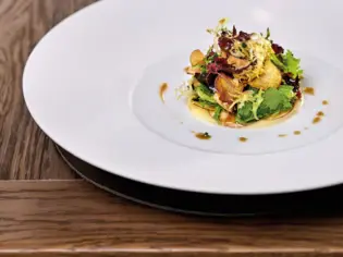 Ein Teller mit Essen auf einem Tisch, kunstvoll garniert.