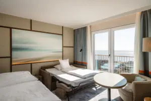 Ein Zimmer mit einem Bett, Stühlen und einem Tisch.