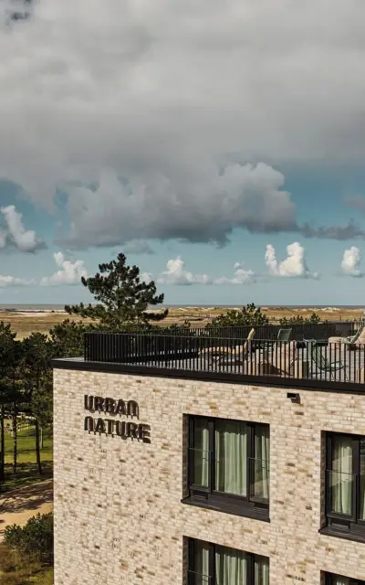 Das Urban Nature Hotel mit einer Dachterrasse mit Blick auf den Strand.