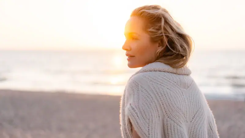 Eine Frau blickt auf den Sonnenuntergang.