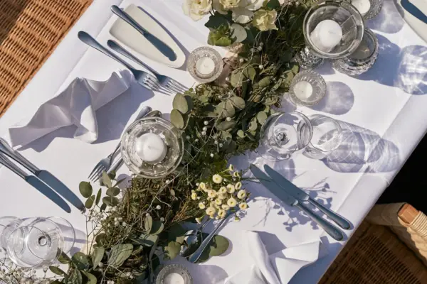 Ein Tisch dekoriert mit Blumen und Kerzen in Vasen.