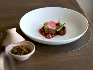 A plate of food on a table, artfully garnished.